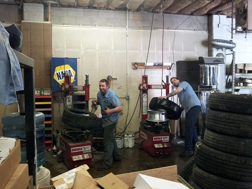 Image of Iowa City Tire & Service's technicians working on tires in the auto shop.