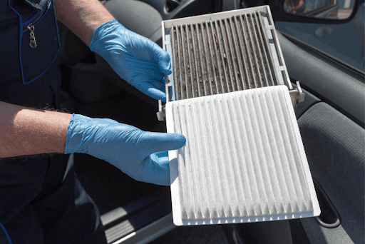 Why do you need to change the cabin air filter in your car? With Iowa City Tire and Service in Iowa City, IA. Image of mechanic holding dirty cabin air filter next to new clean air filter while wearing blue gloves.