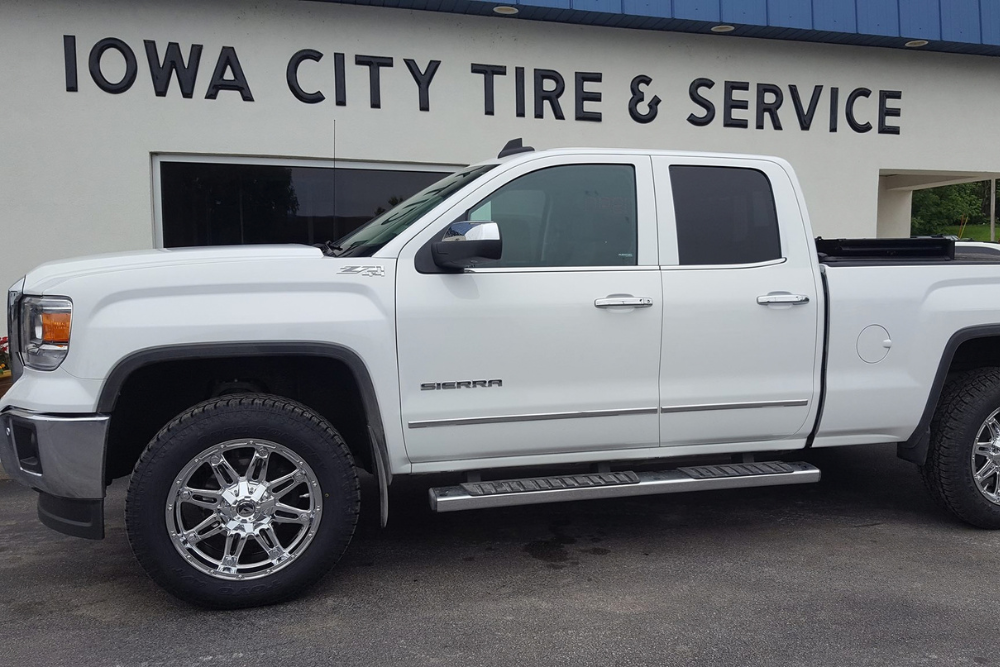 Tire Inspection in Iowa City, IA at Iowa City Tire and Service. Image of GMC Sierra truck with new tires ready for safe rainy weather driving in Iowa City, IA
